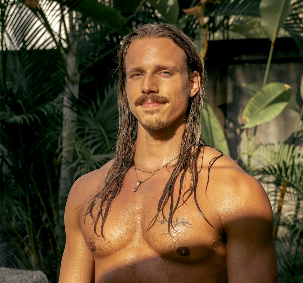 Christian Van Camp in warm evening light among tropical leaves