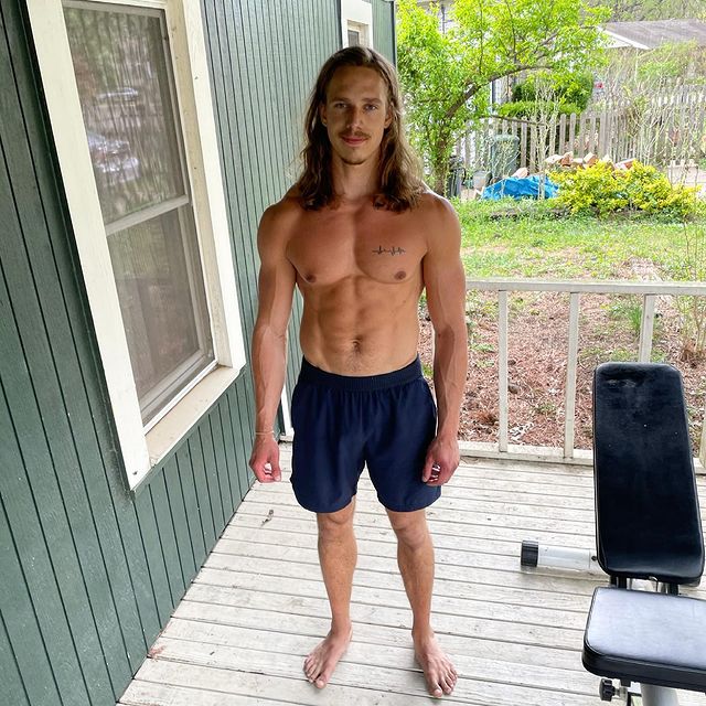 Christian standing barefoot on a wooden porch after a workout